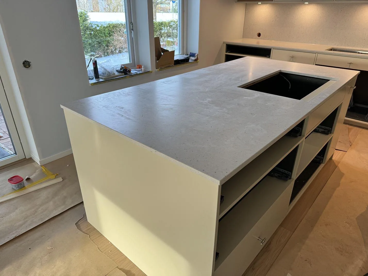 Stor köksö i Silestone Lime Delight, matt kvartskomposit, monterad på vita köksstommar under köksrenovering i Höganäs.