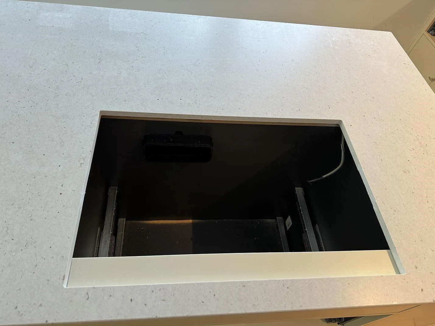 Detalj av hällöppning i köksö av Silestone Lime Delight, matt Mocka-yta, med ljus kvartskomposit i Höganäs.