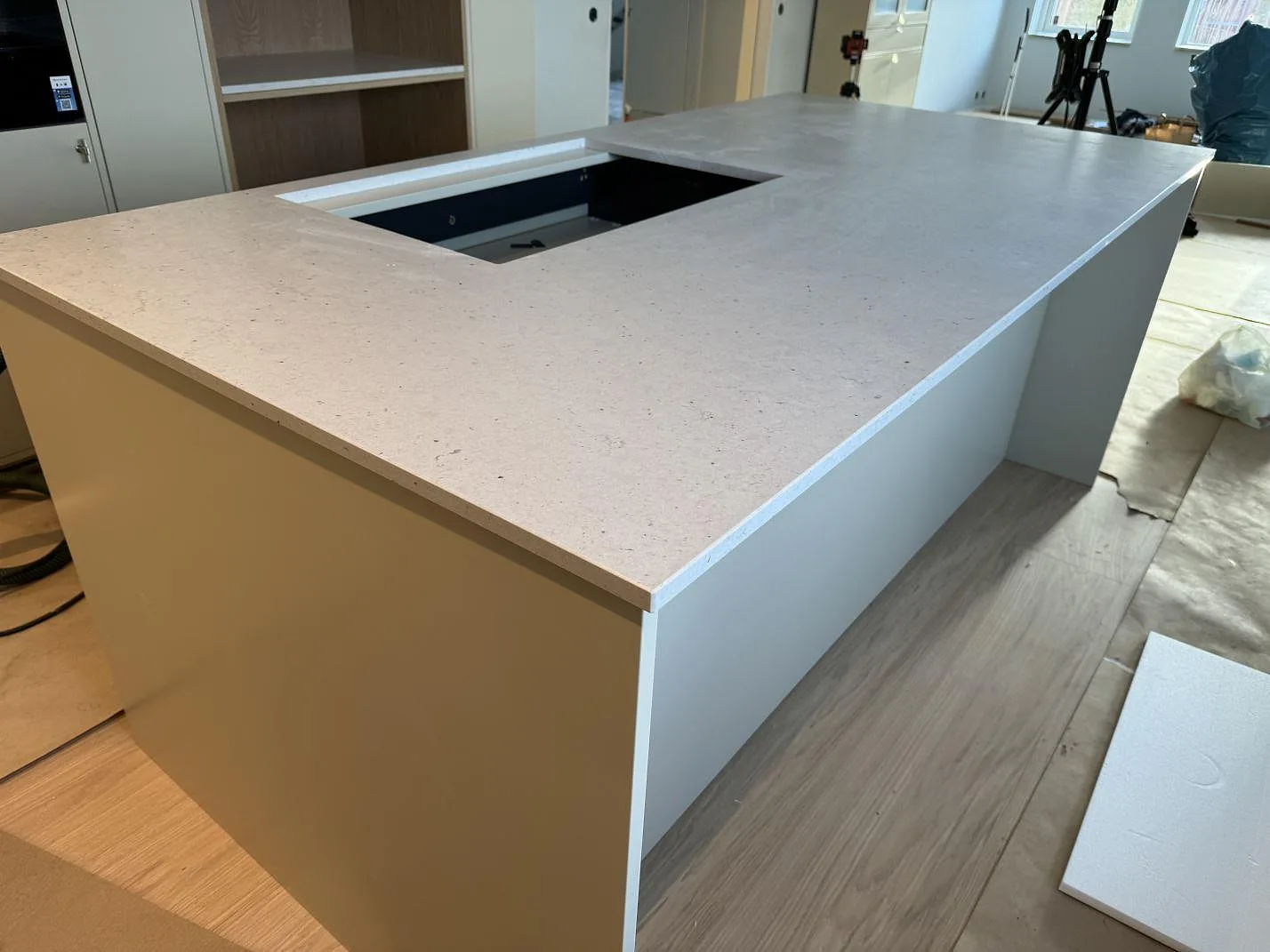 Sidovy av stor köksö med bänkskiva i Silestone Lime Delight, matt Mocka, under montering i Höganäs.