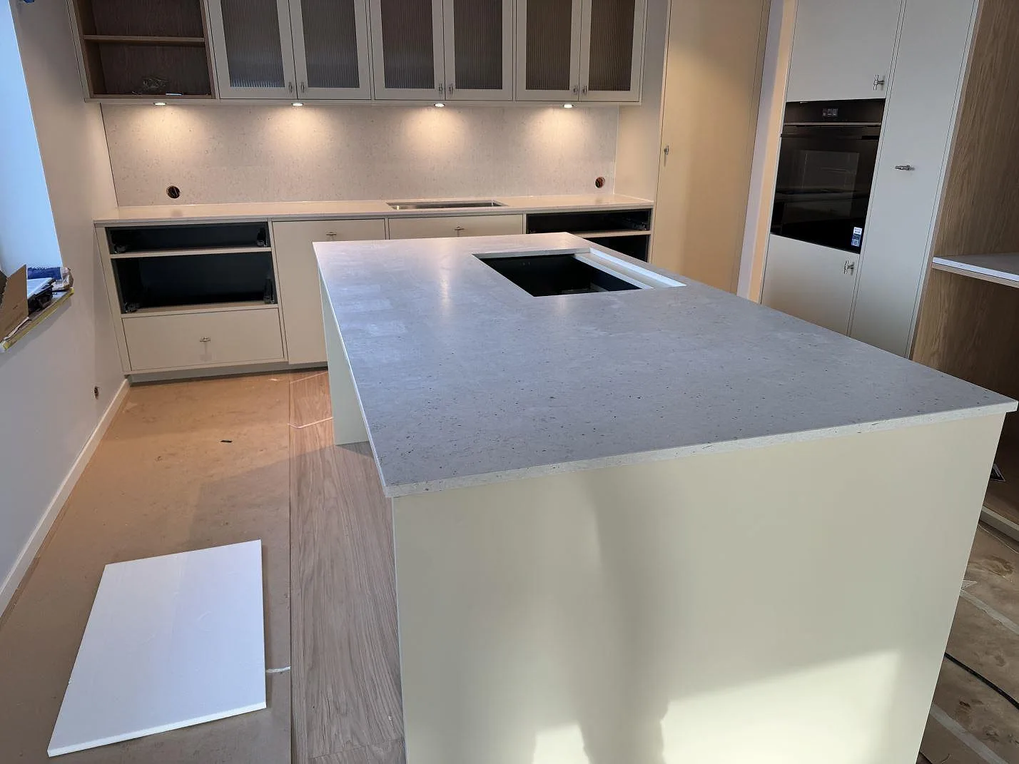 Köksbänkskiva och stor köksö i ljus Silestone Lime Delight, matt Mocka, med hällöppning och stänkskydd i ett kök i Höganäs.