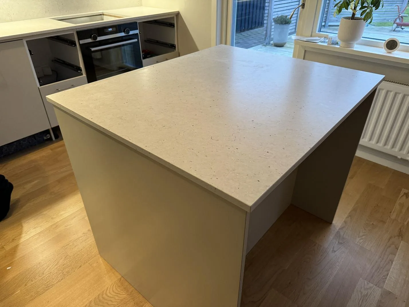 Stor köksö med bänkskiva i vitgrå Silestone Lime Delight, matt Mocka-yta och bakre köksbänk i ett kök i Lidköping.