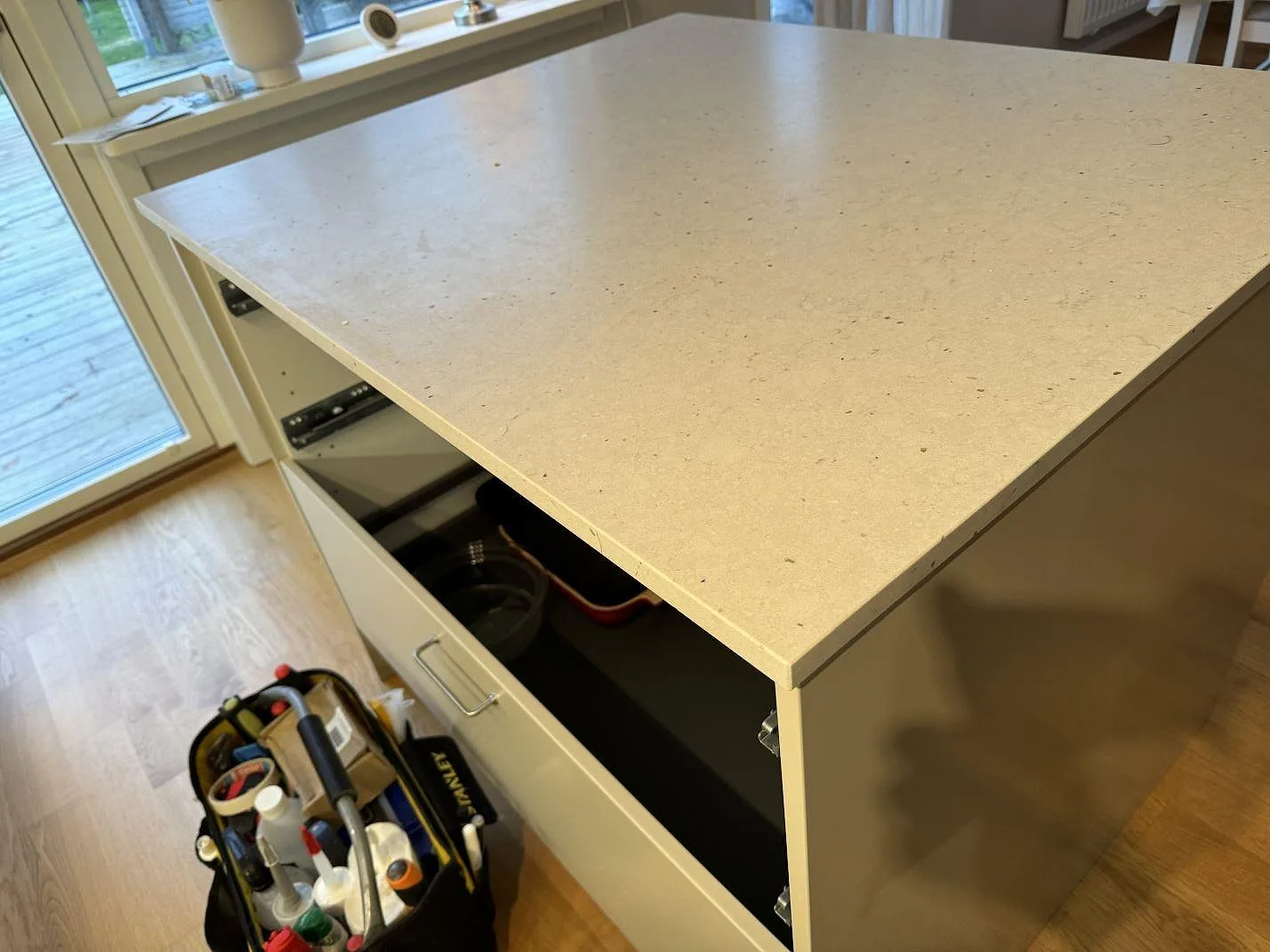 Köksö i Silestone Lime Delight med synlig 20 mm kant, matt ljus komposit och vit köksstomme i Lidköping.