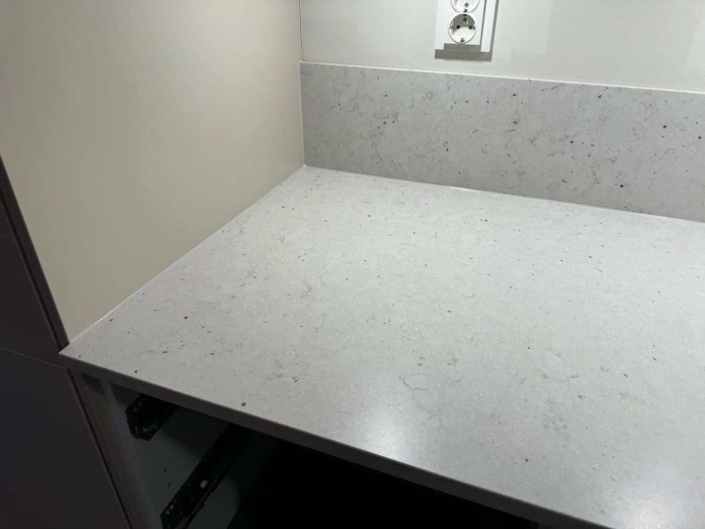 Närbild på bänkskiva och låg stänkkant i Silestone Lime Delight, matt Mocka, vid väggbänk i kök i Lidköping.