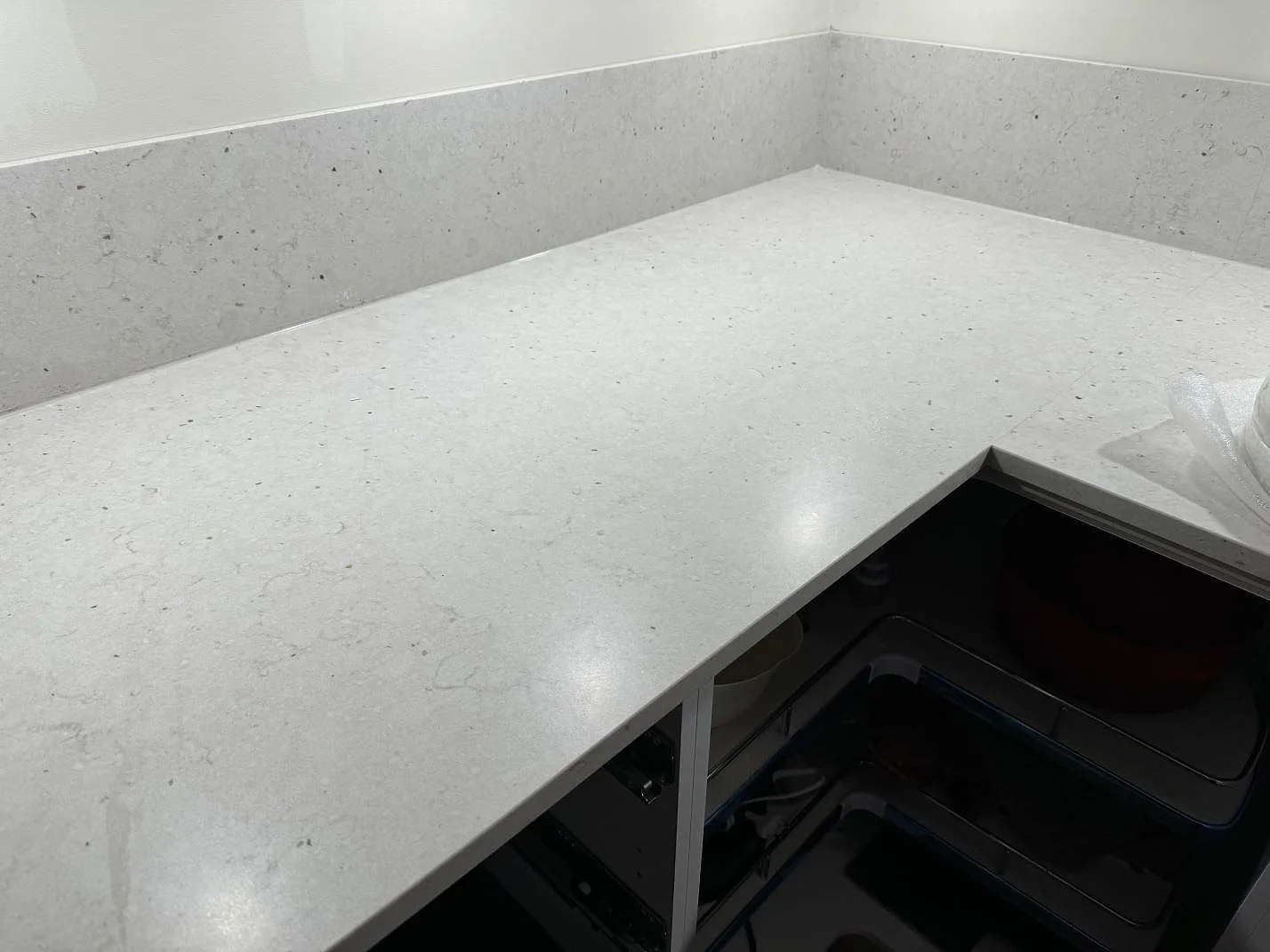 Väggbänk i Silestone Lime Delight med låg stänkkant, matt finish och utskärning för diskho under montering i Lidköping.
