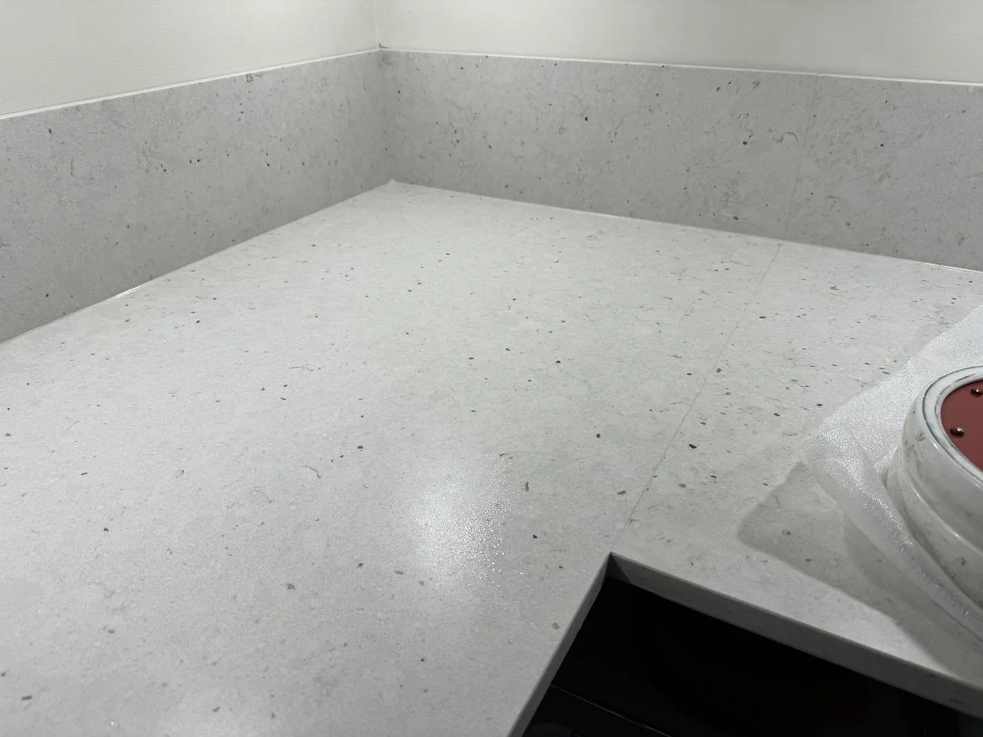 Detalj av Silestone Lime Delight på köksbänk, matt Mocka-yta med grå speglingar och låg stänkkant i Lidköping.