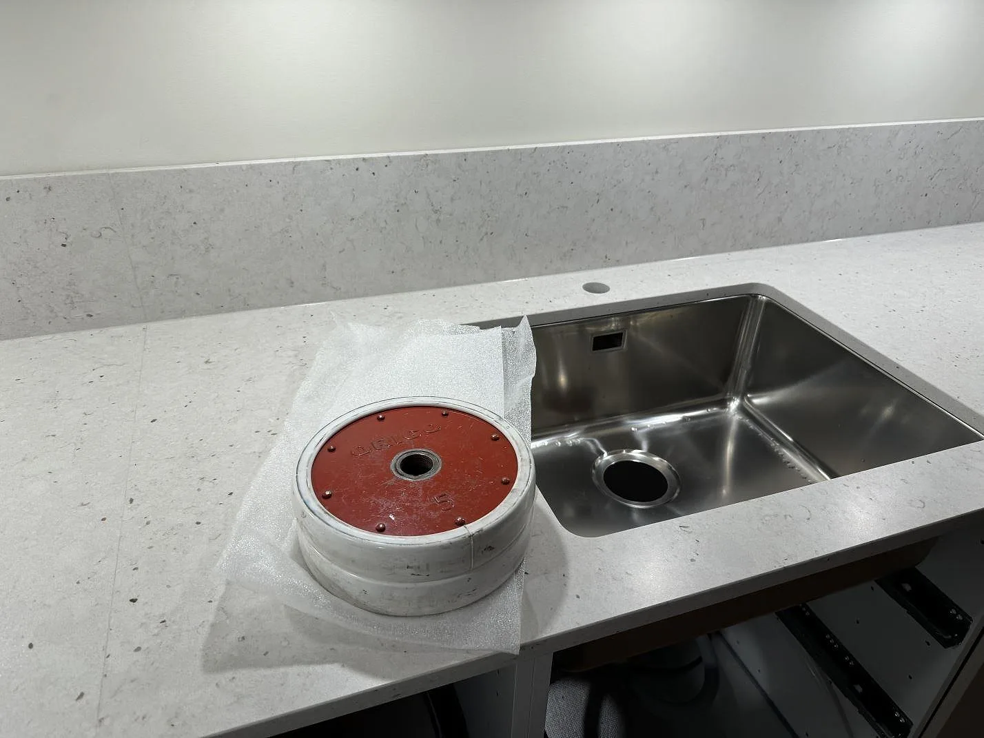 Rostfri diskho i bänkskiva av Silestone Lime Delight med matchande stänkkant och matt vitgrå komposityta i Lidköping.