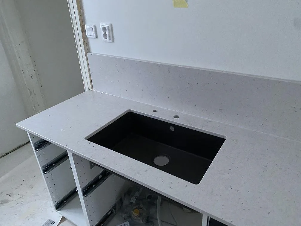 Köksbänkskiva i Silestone Lime Delight, Mocka, med svart diskho och låg stänkkant i ett kök i Lund.