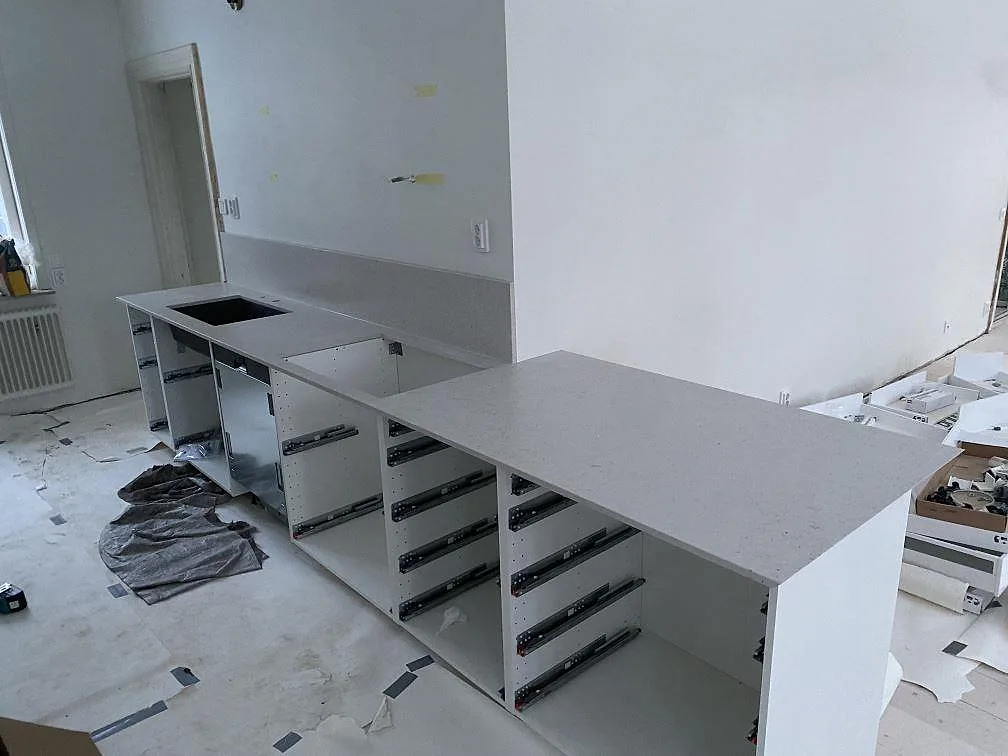 Köksbänkskiva och köksö i vit Silestone Lime Delight, Mocka, under montering i ett kök i Lund.