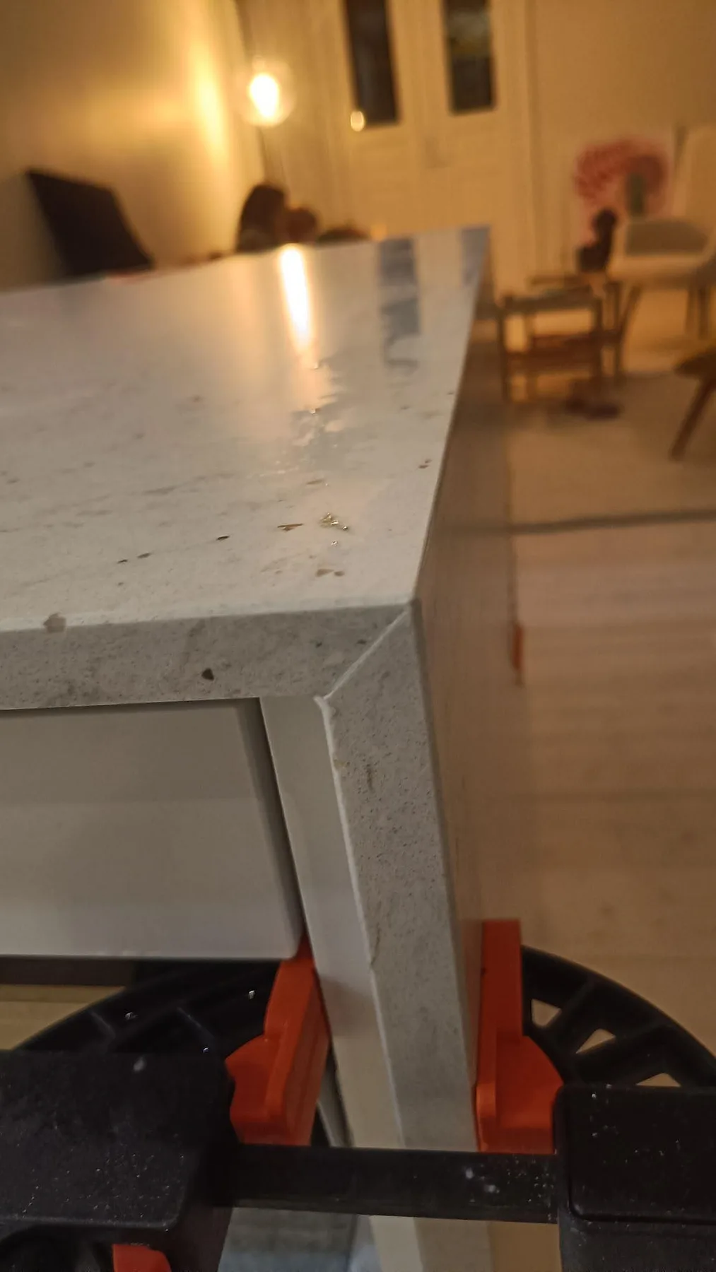 Detalj av monterad Silestone Lime Delight med matt Mocka-yta, ljus teckning och orange klämmor vid köksön i Lund.