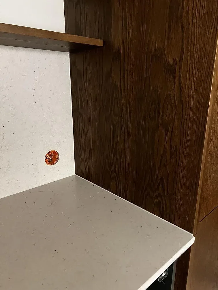 Hörnvy av Silestone Lime Delight i matt Mocka med bänk, stänkskydd och mörkt träskåp under montering i Malmö.