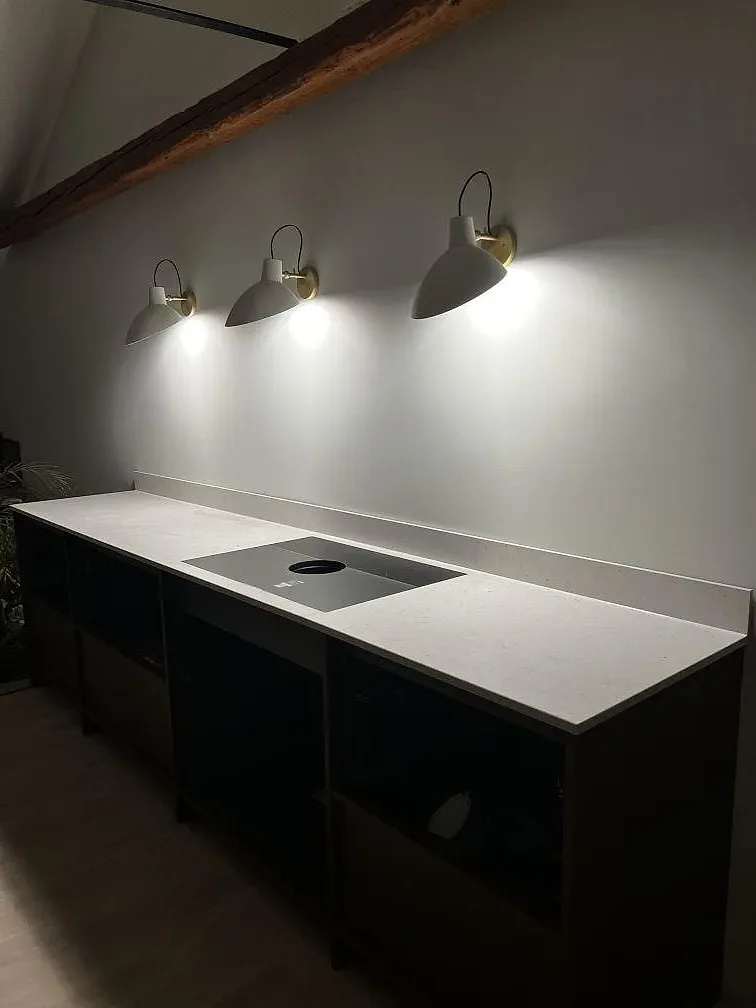 Köksbänkskiva i ljus Silestone Lime Delight, matt Mocka, med låg stänkkant och mörka köksstommar under montering i Malmö.