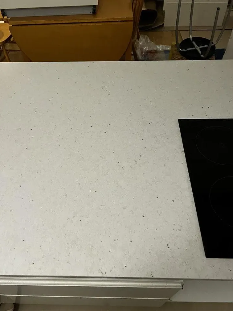 Detalj av Silestone Lime Delight med matt Mocka-yta och spishäll i kanten av köksön i Malmö.