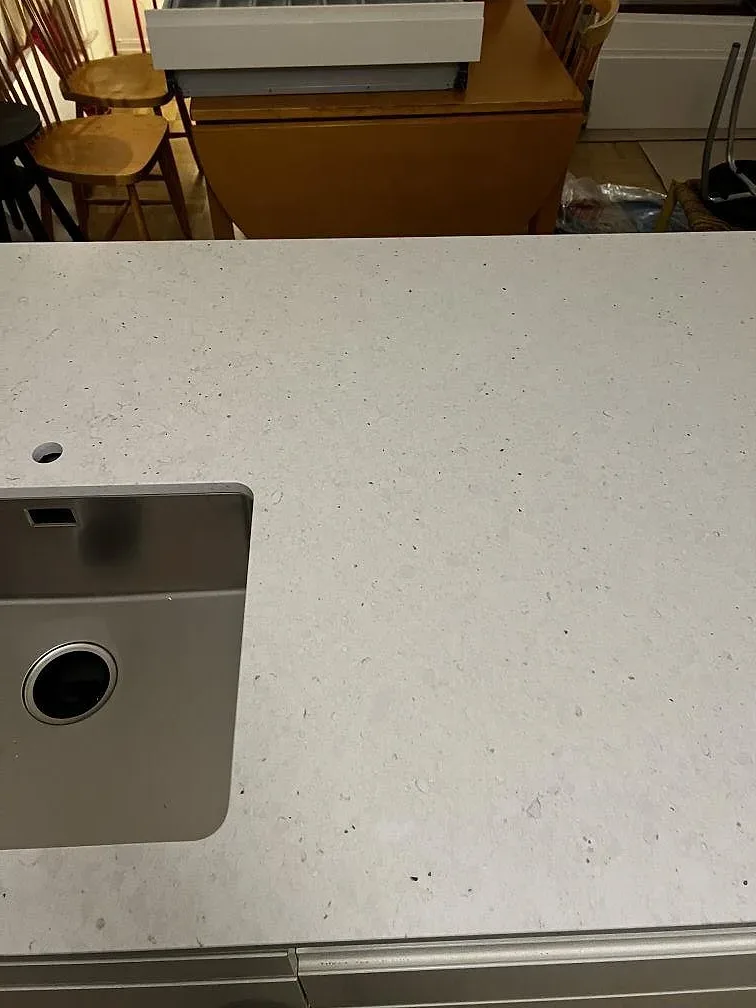 Närbild av vit Silestone Lime Delight med matt yta och rostfri diskho i en köksö i Malmö.