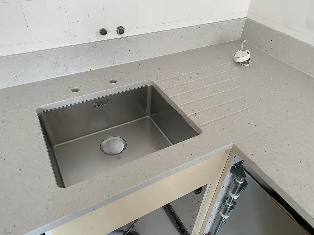 Närbild på Silestone Lime Delight i matt kvartskomposit med underlimmad rostfri diskho, avrinningsspår och stänkskydd i Malmö.
