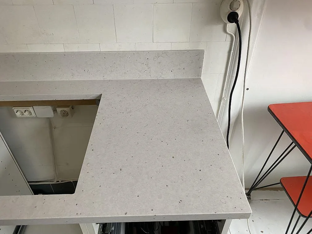 Höger avslut på köksbänkskiva i Silestone Lime Delight med ljus matt kvartskomposit och stänkskydd under montering i Malmö.