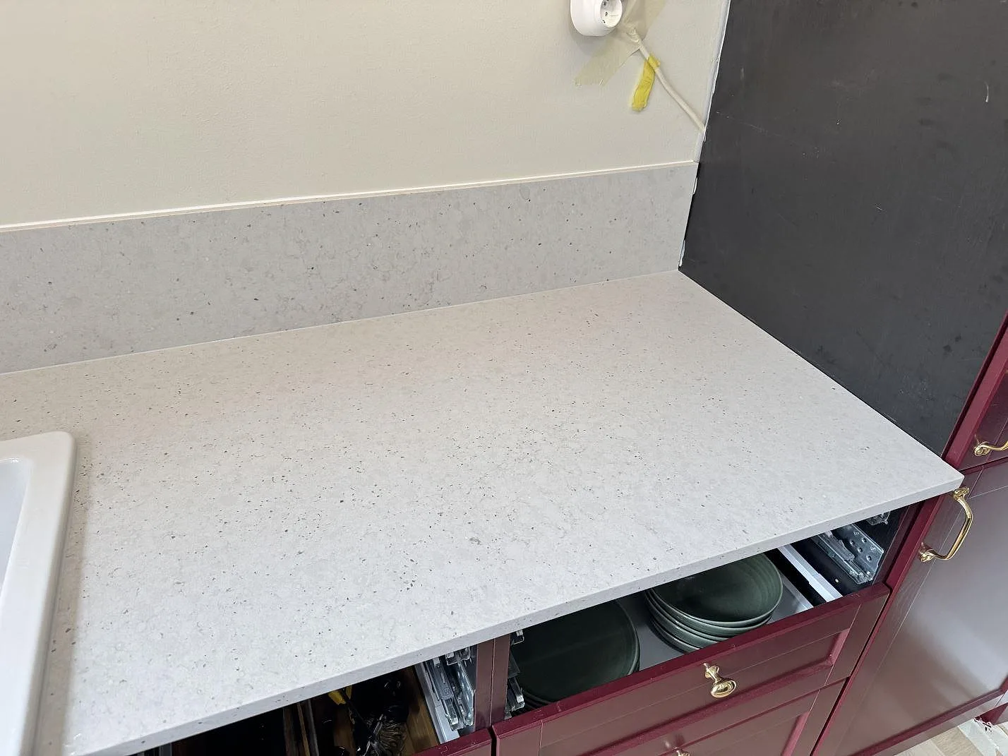 Köksbänkskiva i Silestone Lime Delight, matt Mocka, med 12 mm stänkskydd och röd köksinredning i Malmö.