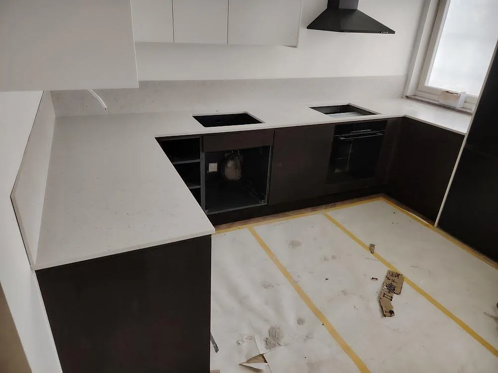 Köksbänkskiva i matt Silestone Lime Delight med matchande stänkskydd, diskhoöppning och hällöppning i ett kök i Nacka.