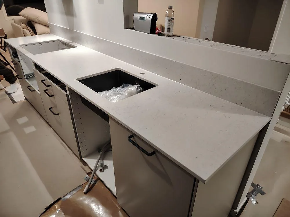 Närbild på Silestone Lime Delight köksbänkskiva i matt komposit med 12 mm stänkskydd och synliga monteringsurtag i Nacka.