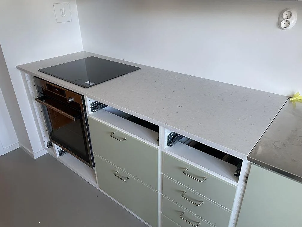 Köksbänkskiva i ljusgrå Silestone Lime Delight, matt Mocka-yta, med spishäll och ugn i ett kök i Stockholm.
