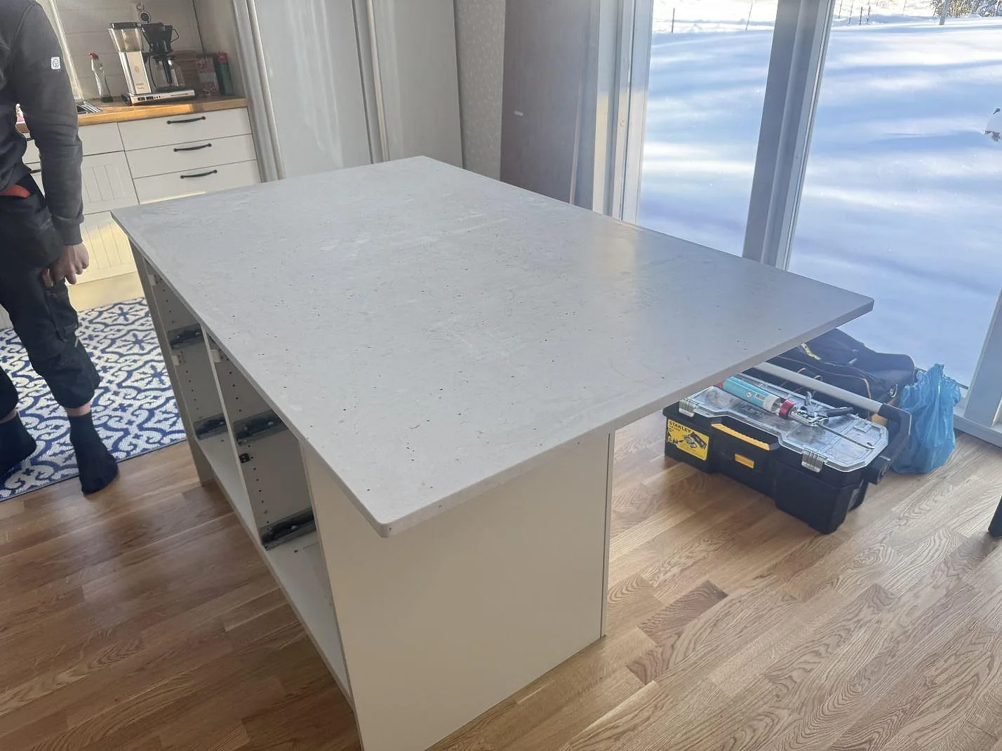 Köksö med bänkskiva i Silestone Lime Delight, 20 mm Mocka, under montering i ett kök i Väckelsång.