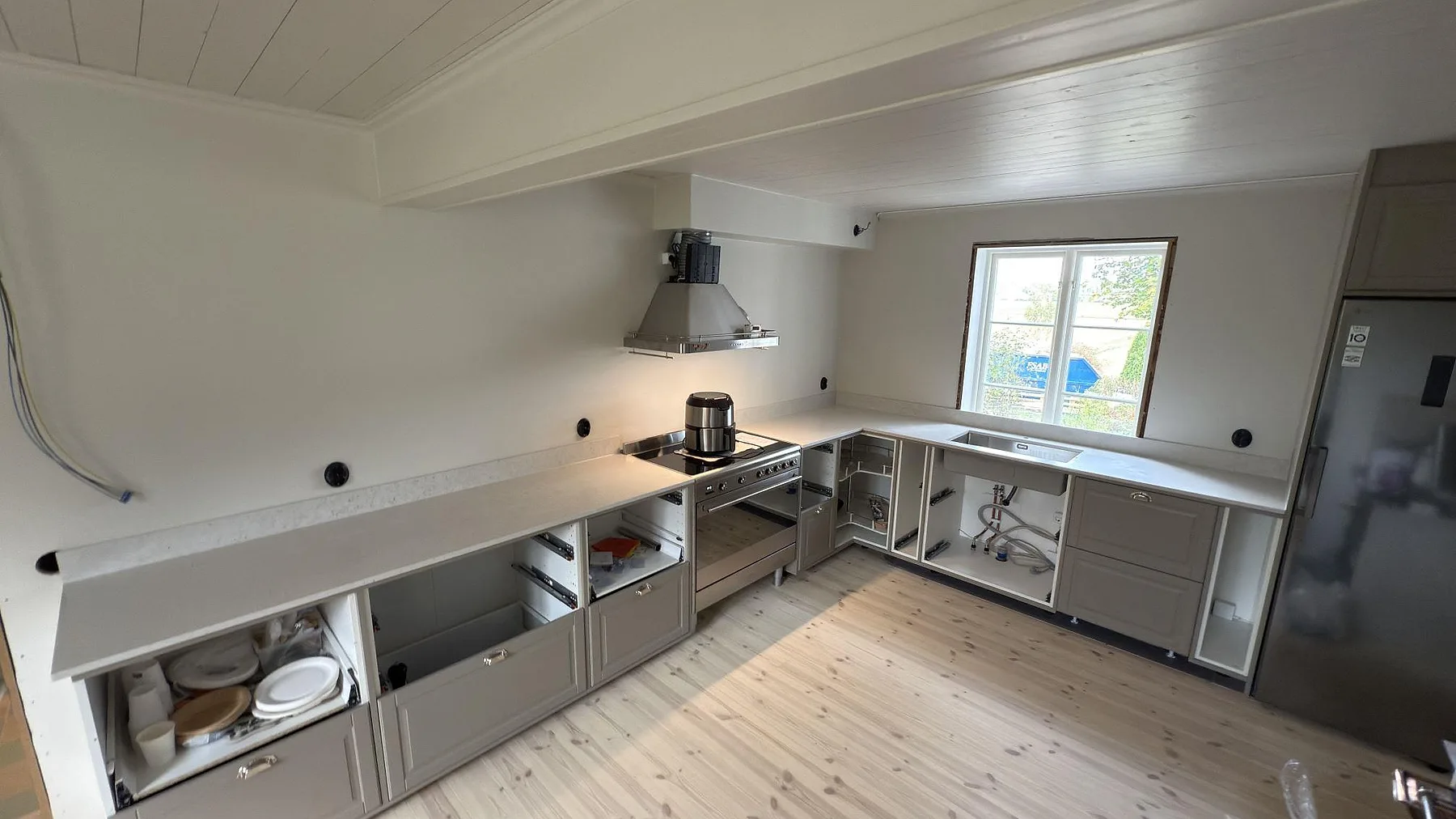 Köksbänkskiva i Silestone Lime Delight, matt Mocka, med 12 mm stänkskydd och rostfri diskho i ett kök under montering i Vänge.