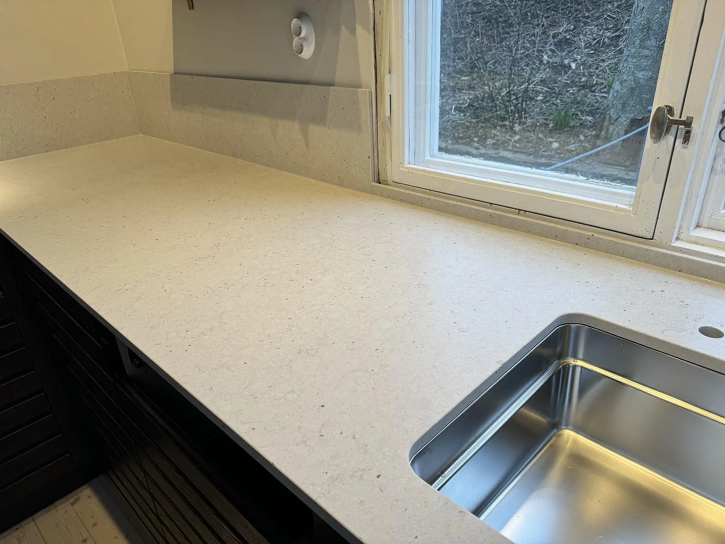 Lång köksbänk i Silestone Lime Delight med stänkskydd, rostfri diskho och ljus stenyta i Västra Frölunda.