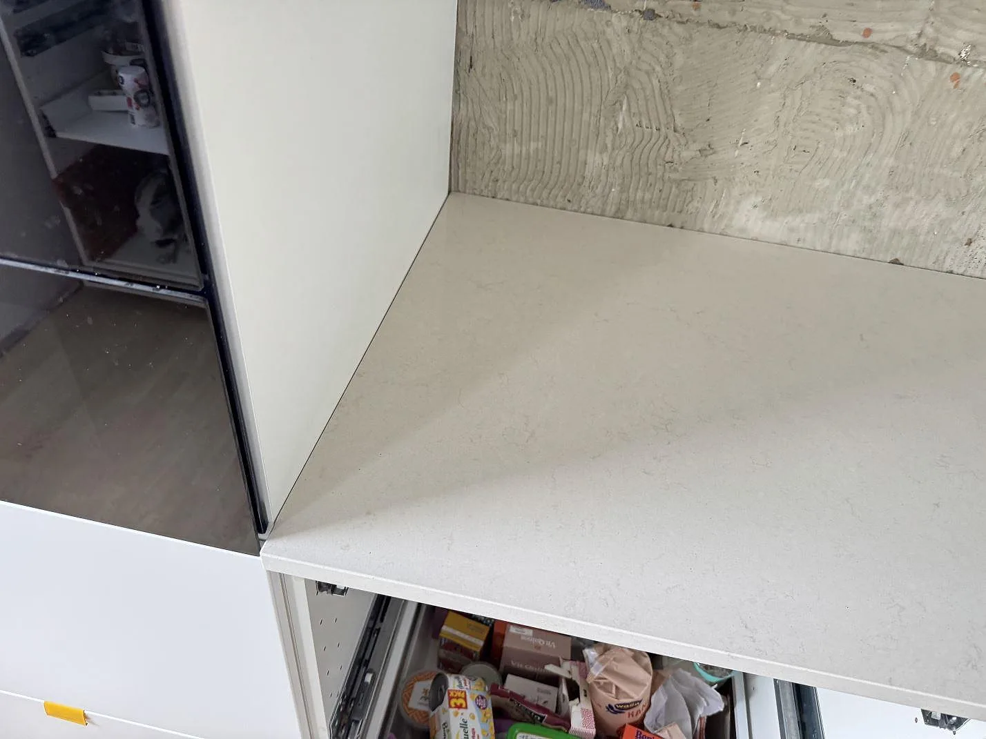 Rak köksbänkskiva i polerad Silestone Linen Cream, kvartskomposit, mot ofärdig vägg under montering i Bunkeflostrand.