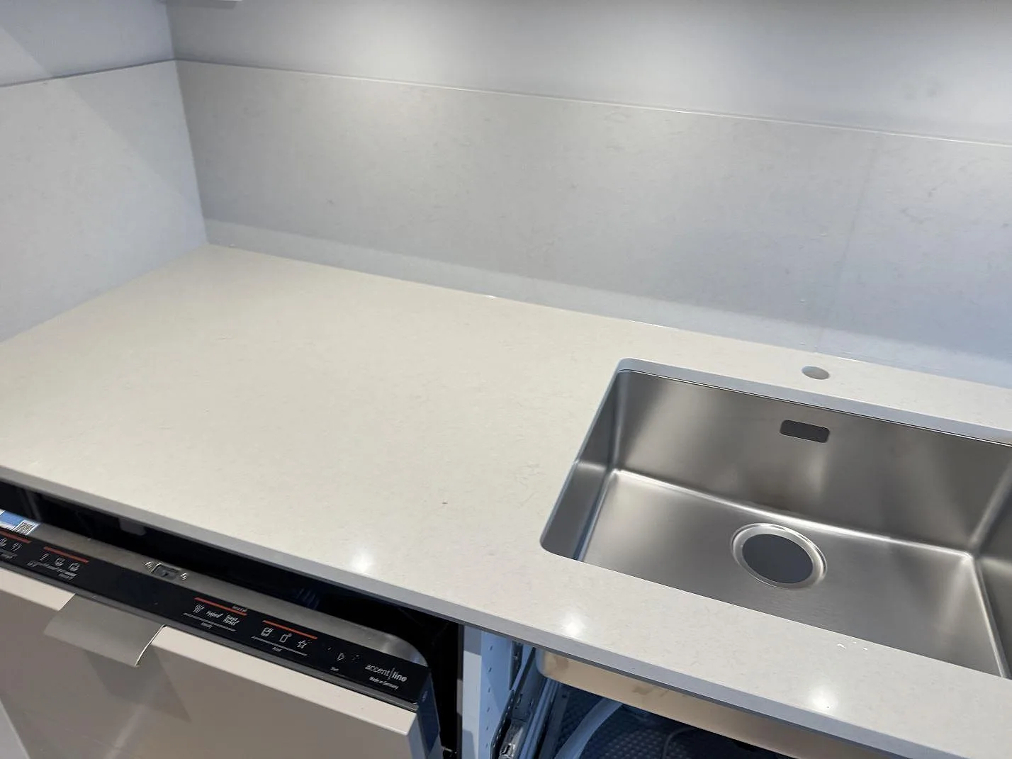 Närbild av Silestone Linen Cream bänkskiva med rostfri diskho, blandarhål och polerad yta i Bunkeflostrand.
