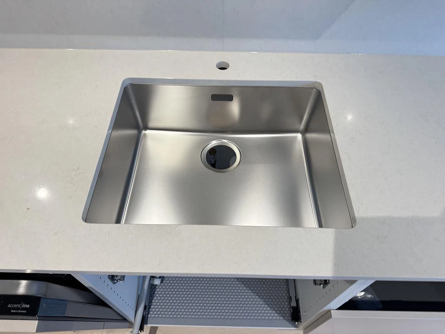 Rostfri diskho infälld i ljus Silestone Linen Cream bänkskiva med polerad komposityta i Bunkeflostrand.