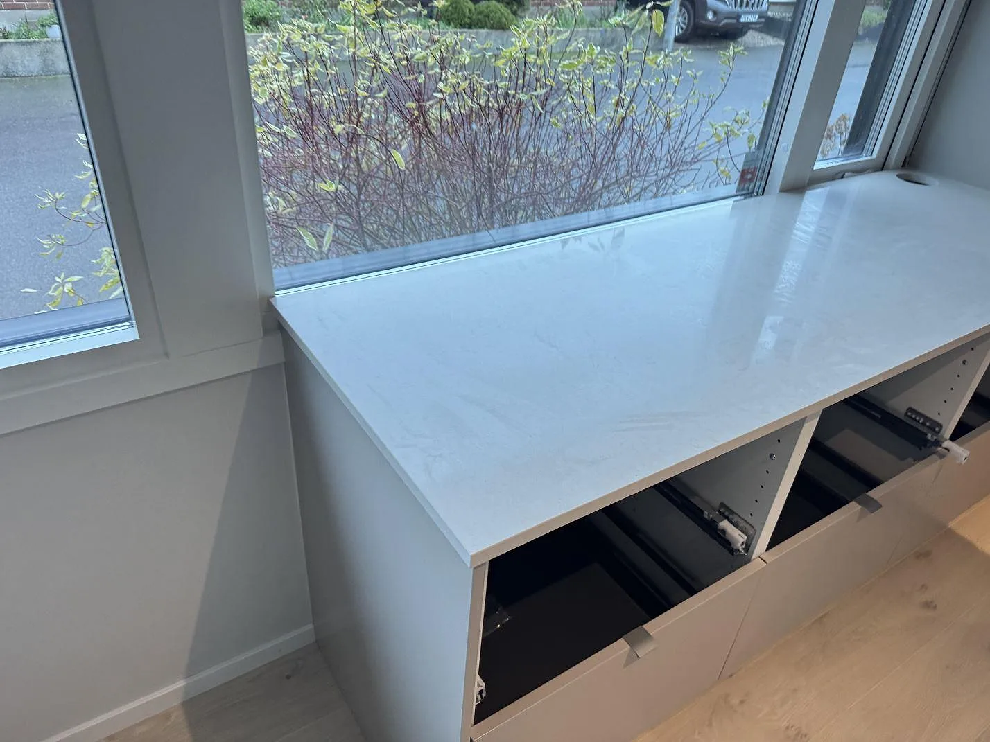 Separat bänkyta vid fönster i polerad Silestone Linen Cream med ljusa köksstommar i Bunkeflostrand.