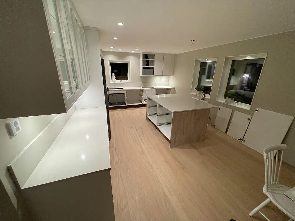 Polerad Silestone Linen Cream som lång köksbänk och köksö i ett ljust kök i Falun.