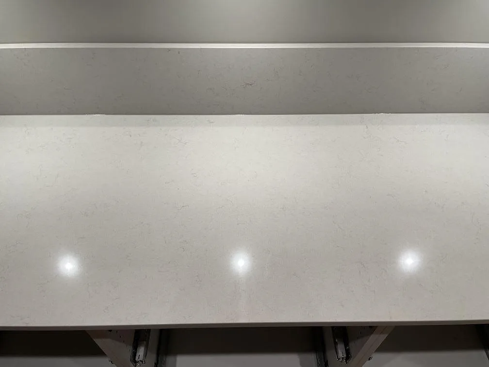 Detalj av polerad Silestone Linen Cream med diskret mönstring och uppvikt stänkkant i Falun.