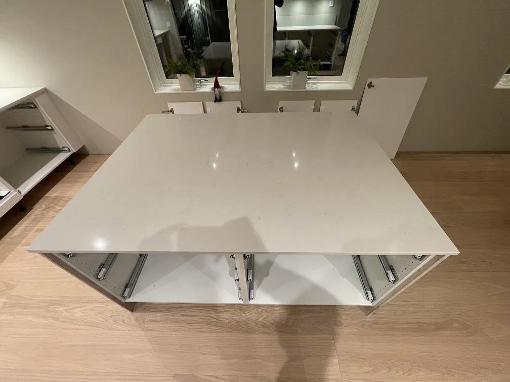 Köksö med bred skiva i polerad Silestone Linen Cream över öppna stommar i Falun.