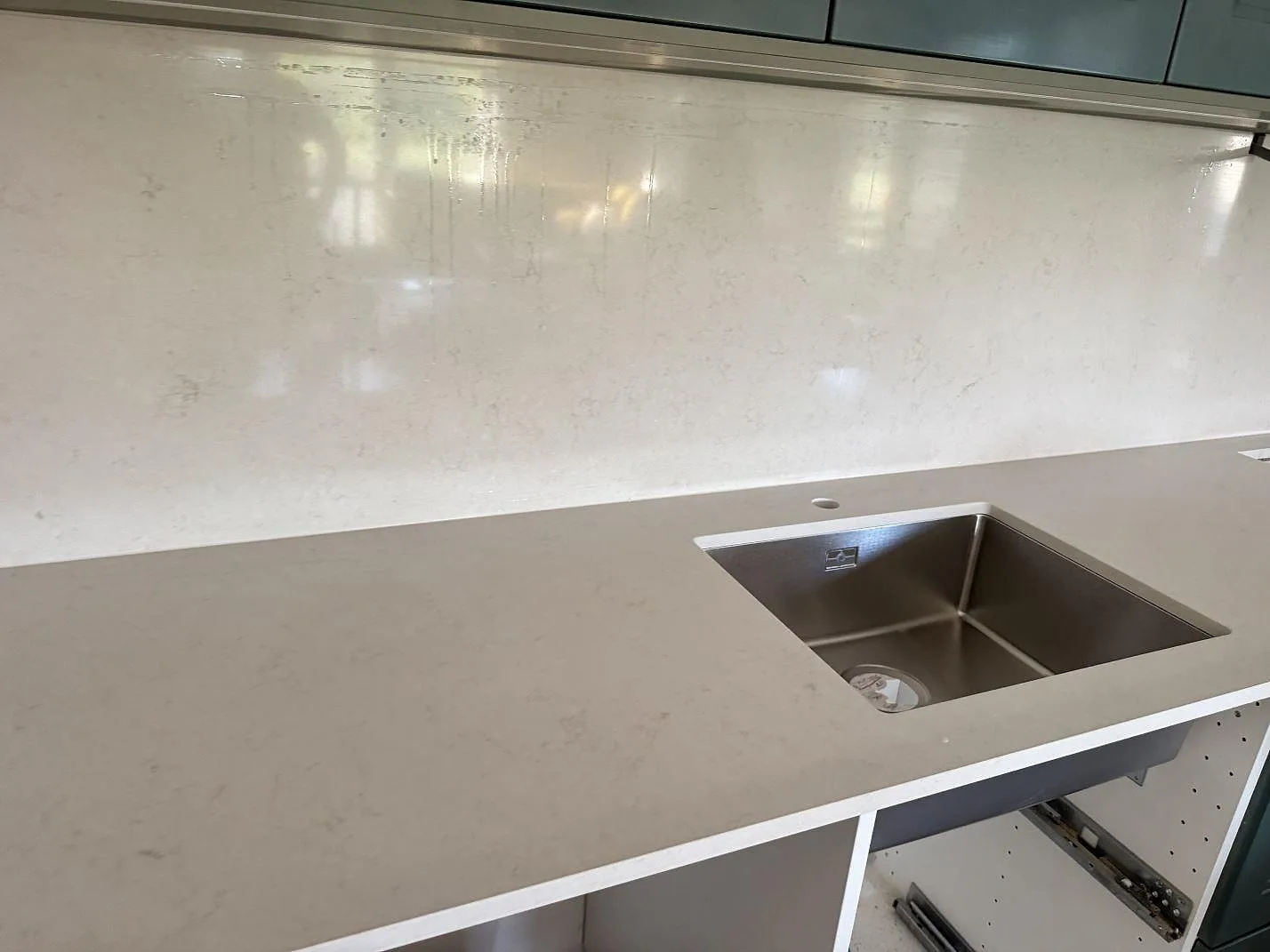 Köksbänkskiva i polerad Silestone Linen Cream med rostfri diskho och blankt stänkskydd i samma komposit, Hjärup.