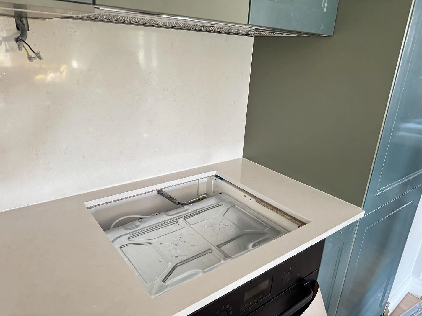 Detalj av öppet hälluttag i köksbänkskiva av polerad Silestone Linen Cream med matchande stänkskydd, Hjärup.