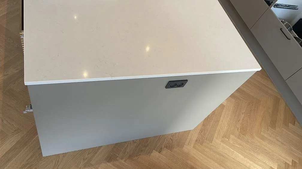 Gavel på köksö med polerad Silestone Linen Cream, tunn ljus kant och träparkett i kök i Hornslet.