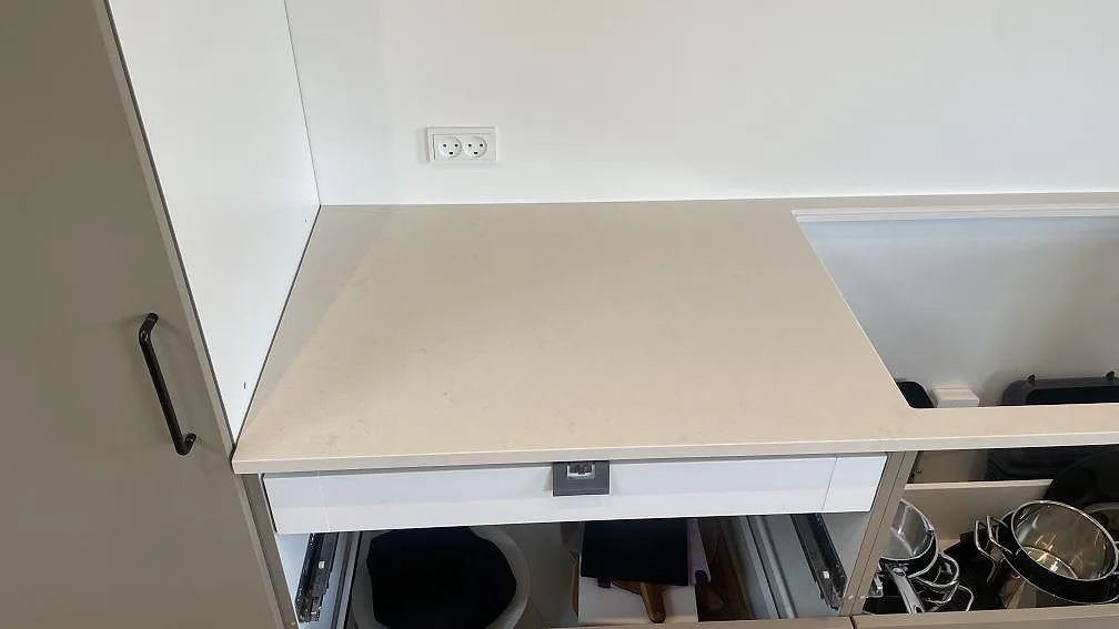 Väggbänk i polerad Silestone Linen Cream med stort urtag och öppna köksstommar under montering i Hornslet.