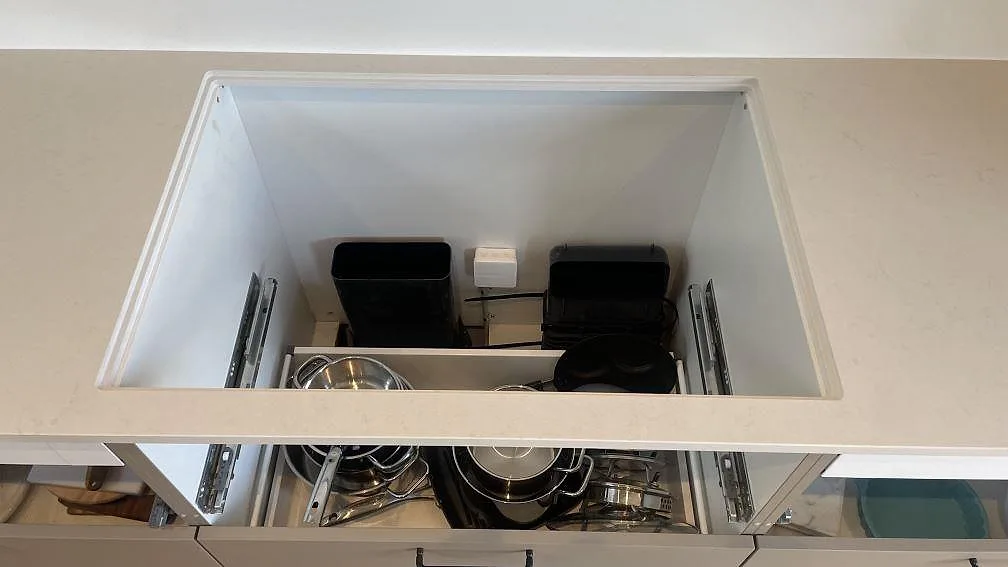 Detalj av stort urtag i en polerad Silestone Linen Cream bänkskiva med förvaring under i Hornslet.