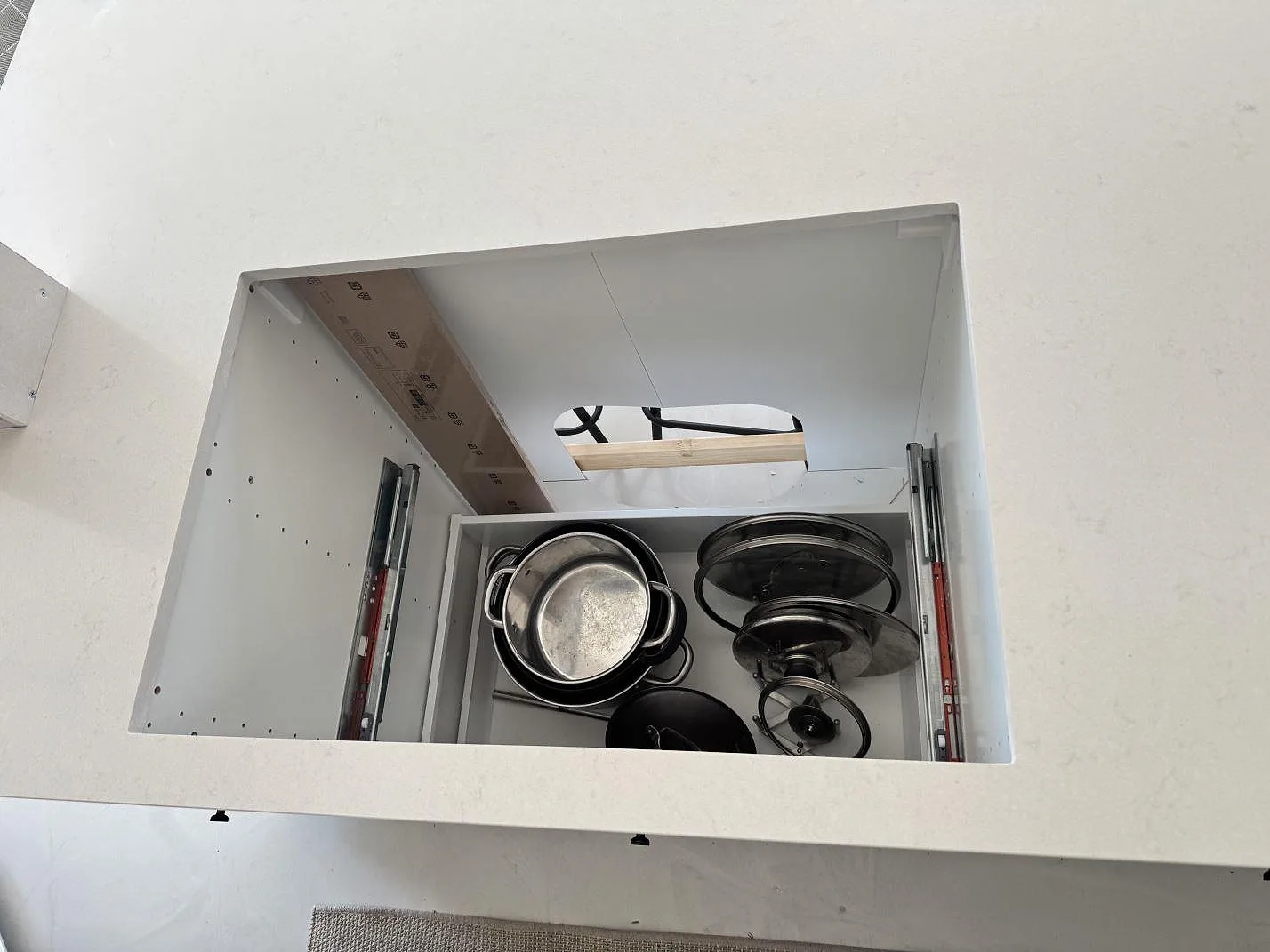 Bänkskiva i polerad Silestone Linen Cream, ljus kvartskomposit, med stort rektangulärt urtag över köksstommar i Lomma.