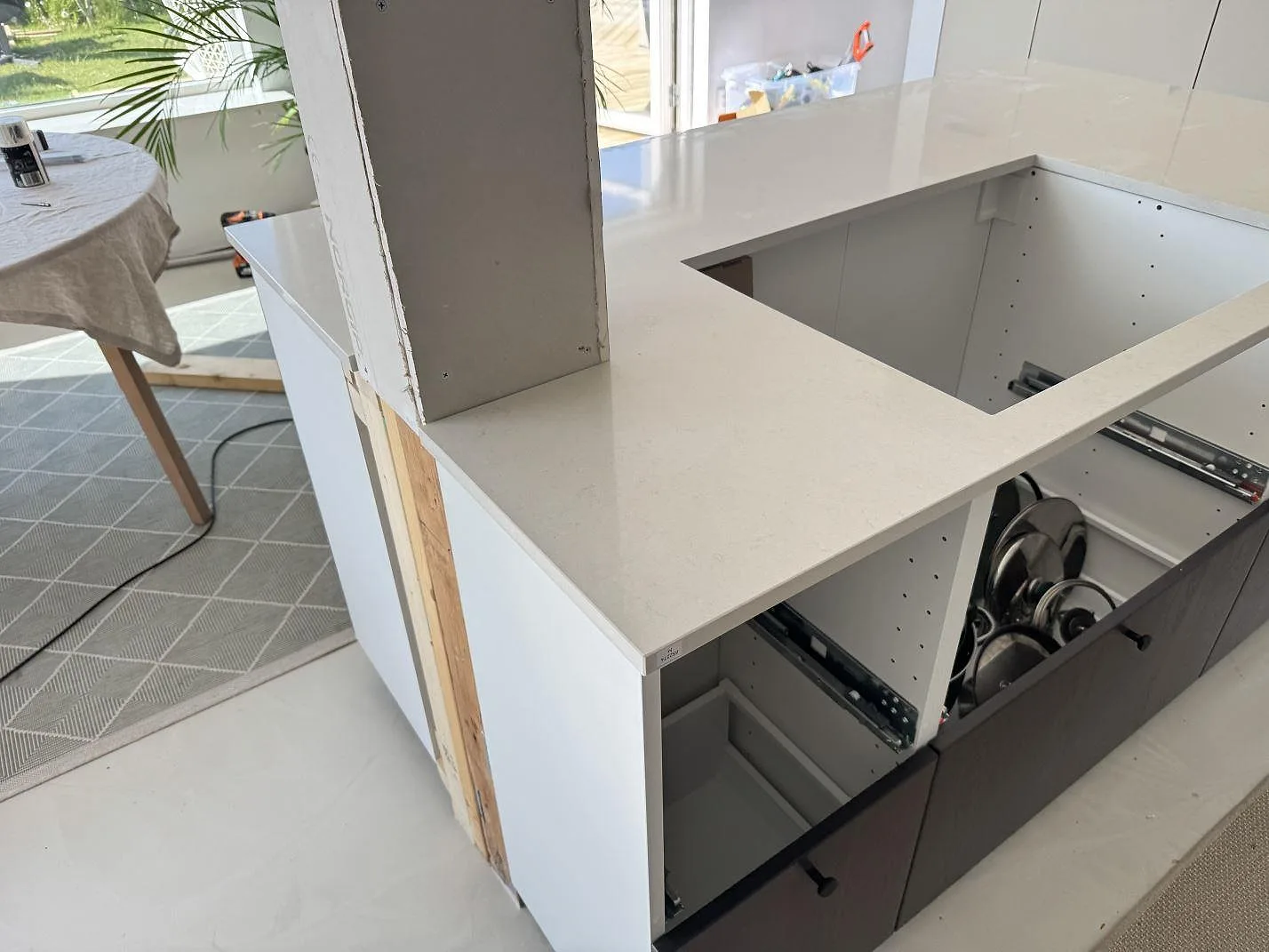 Polerad Silestone Linen Cream i ljus kvartskomposit runt ett stort urtag på en köksbänk under montering i Lomma.