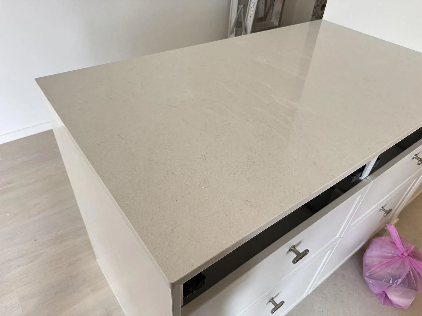Polerad kompositbänkskiva i Silestone Linen Cream med ljus marmorerad yta på en sidobänk i kök i Lund.