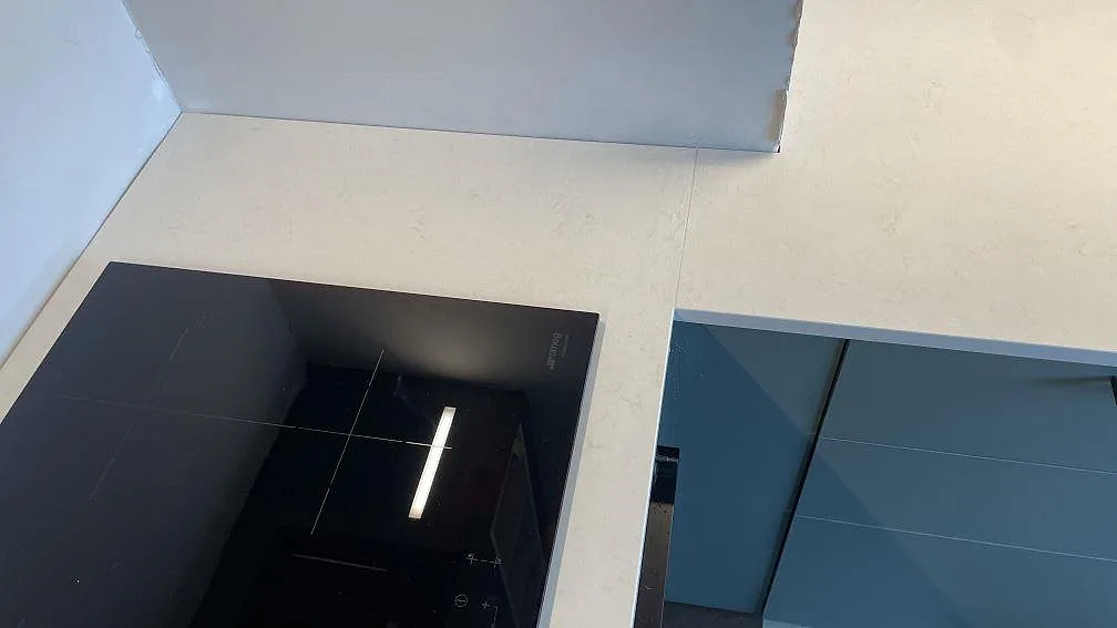 Hällområdet i ett kök i Malmö med polerad köksbänkskiva i Silestone Linen Cream, ljus kvartskomposit och diskret ådring.