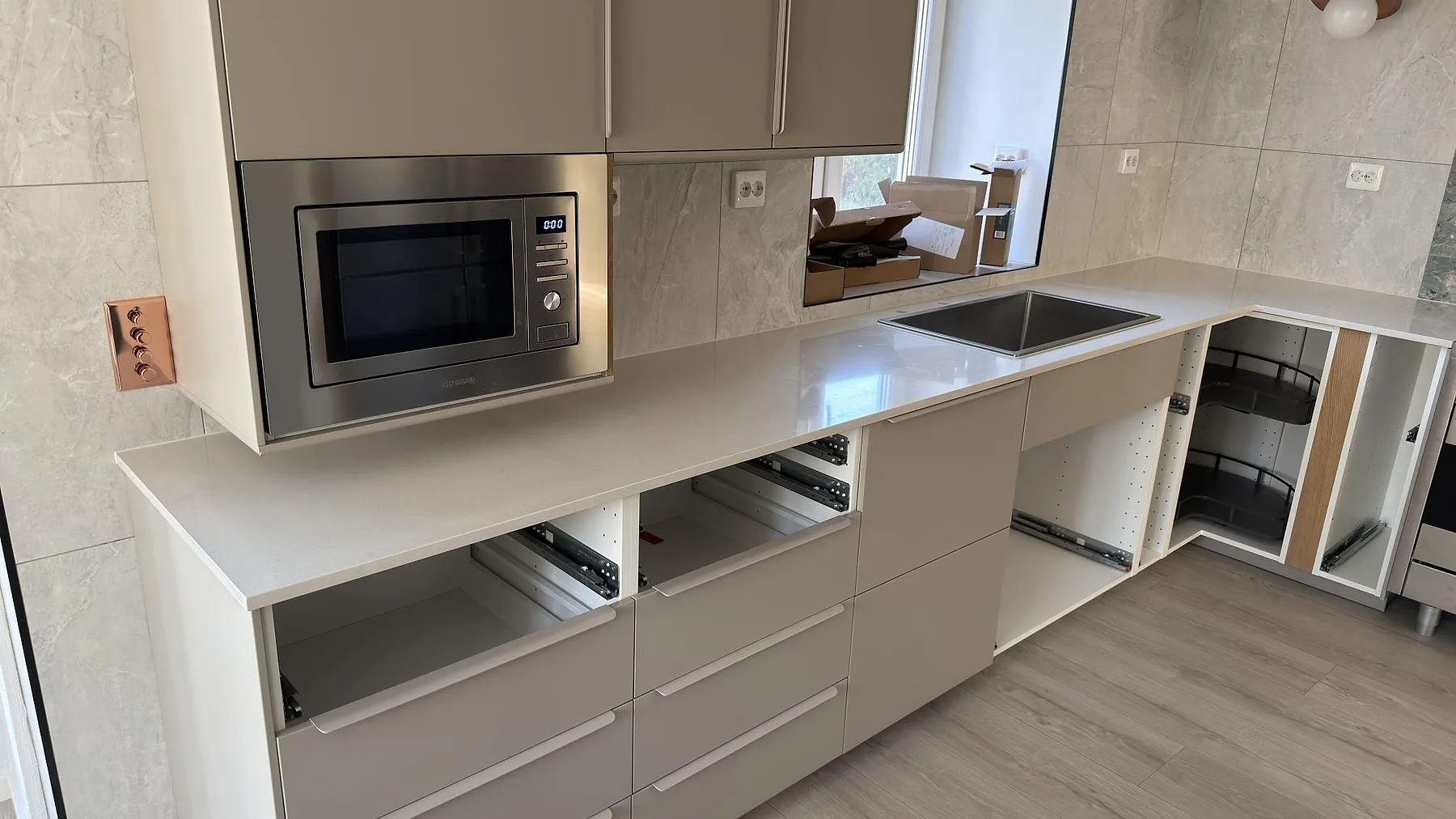 Köksbänkskiva i polerad Silestone Linen Cream med synlig diskho och ljusa köksstommar i Södertälje.