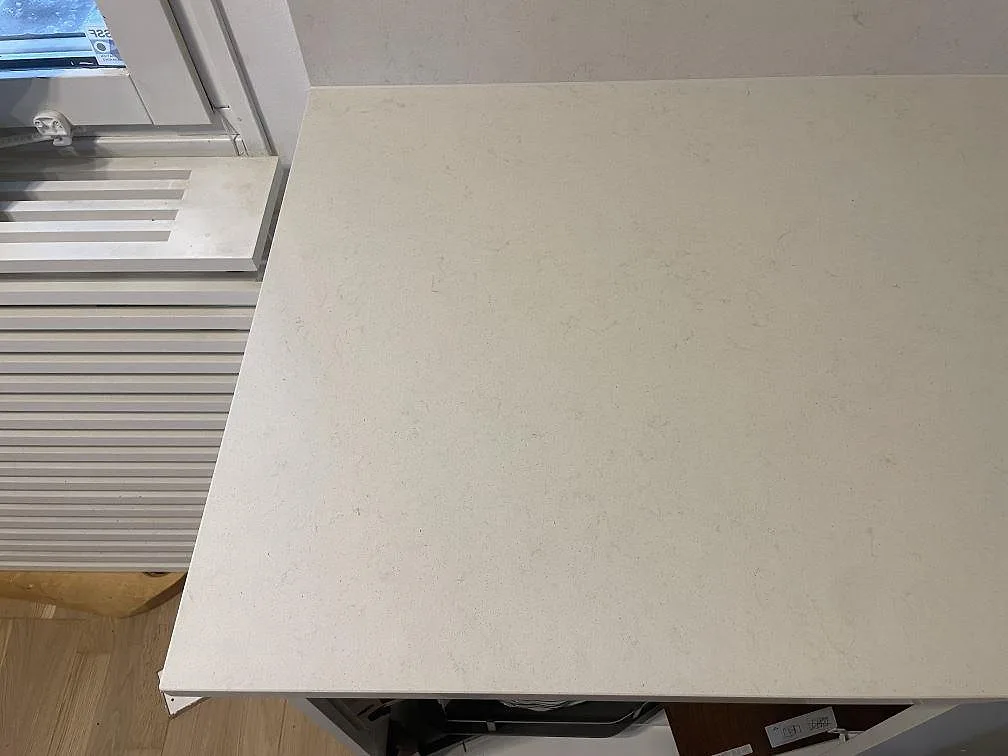 Närbild på ytan av Silestone Linen Cream, polerad krämvit kvartskomposit med fin ådring, på en bänkskiva i Södertälje.
