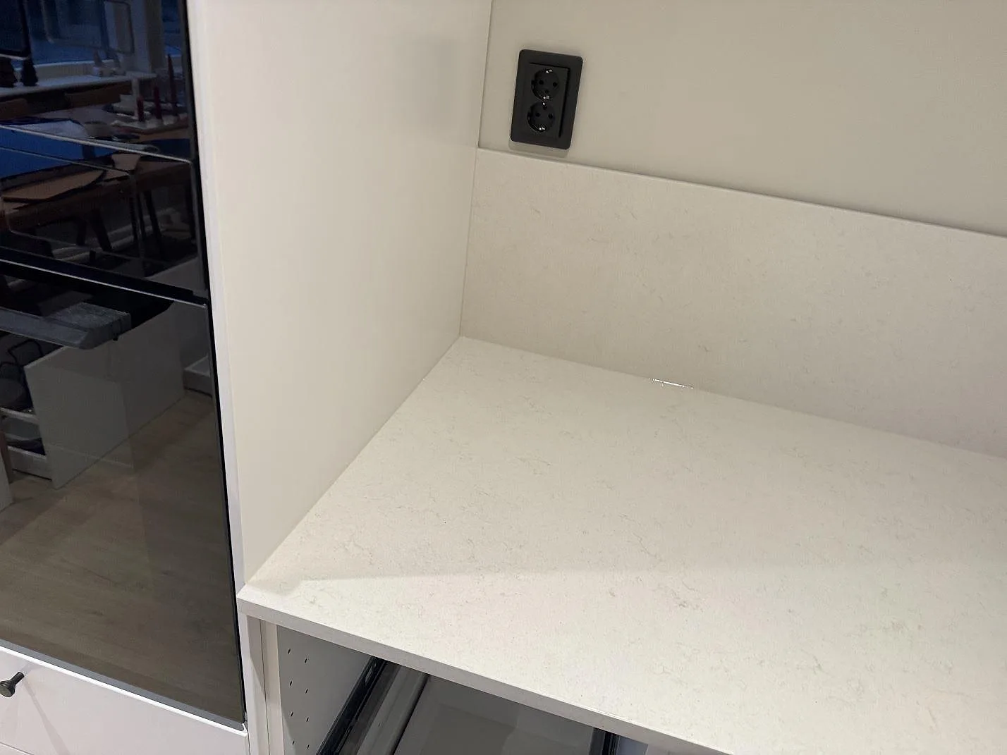 Polerad köksbänkskiva i Silestone Linen Cream, ljus kvartskomposit, med 12 mm stänkskydd vid en högskåpssida i ett kök i Svedala.