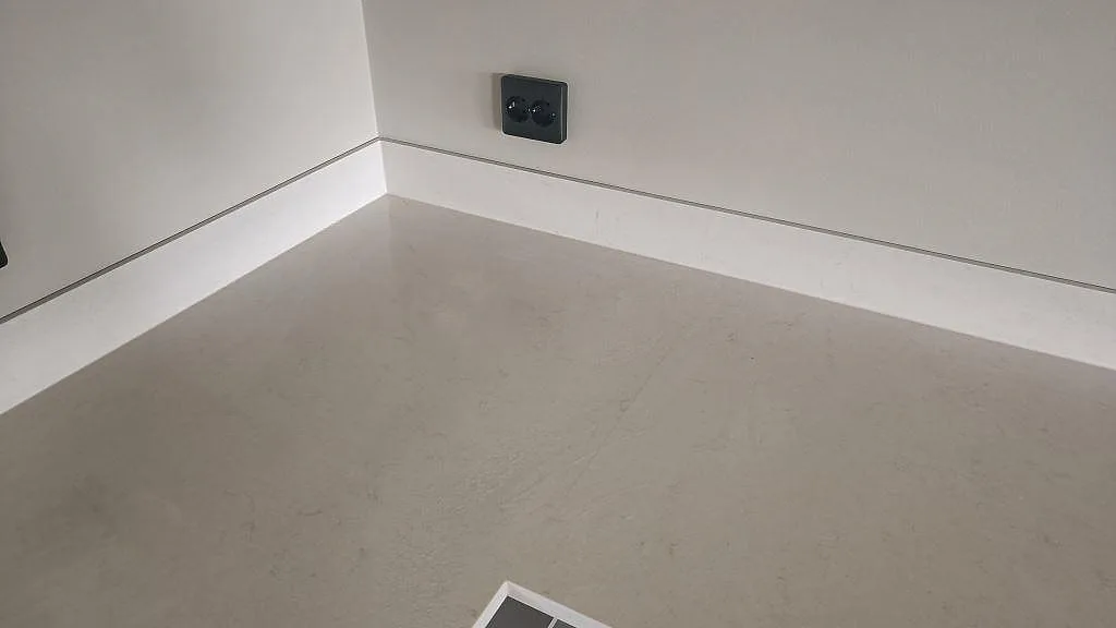 Ytdetalj av polerad Silestone Linen Cream med subtil beige ådring och låg stänkkant i ett kök i Tågarp.