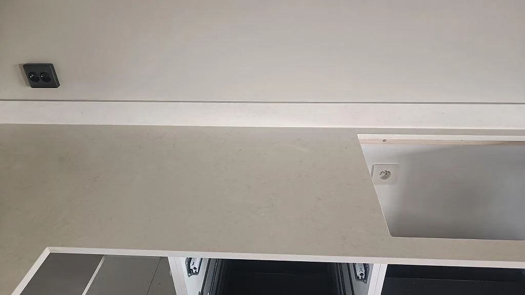 Närbild av polerad Silestone Linen Cream som köksbänkskiva med öppna stommar och rektangulärt urtag i Tågarp.