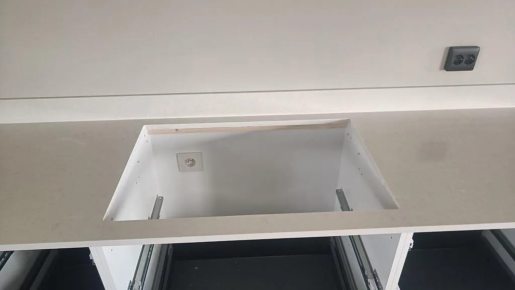 Detalj av köksbänkskiva i polerad Silestone Linen Cream med öppning i stenen och låg stänkkant i Tågarp.