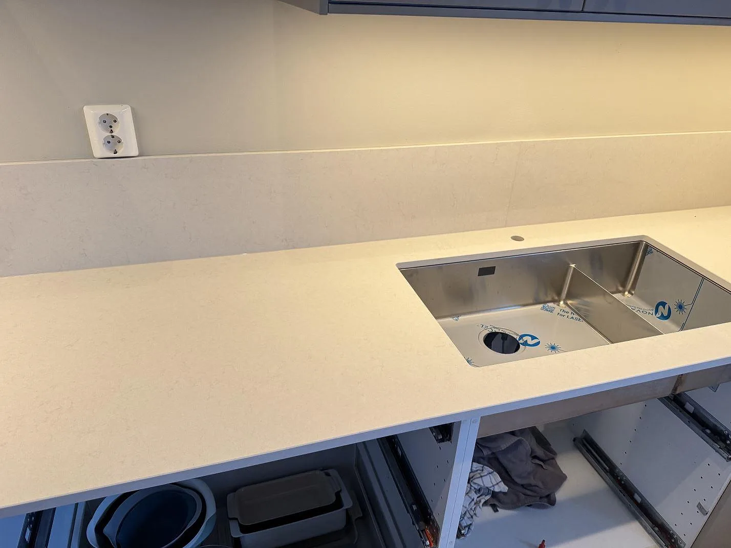 Lång rad i Silestone Linen Cream med underlimmad rostfri diskho och låg stänkkant i ett kök i Växjö.