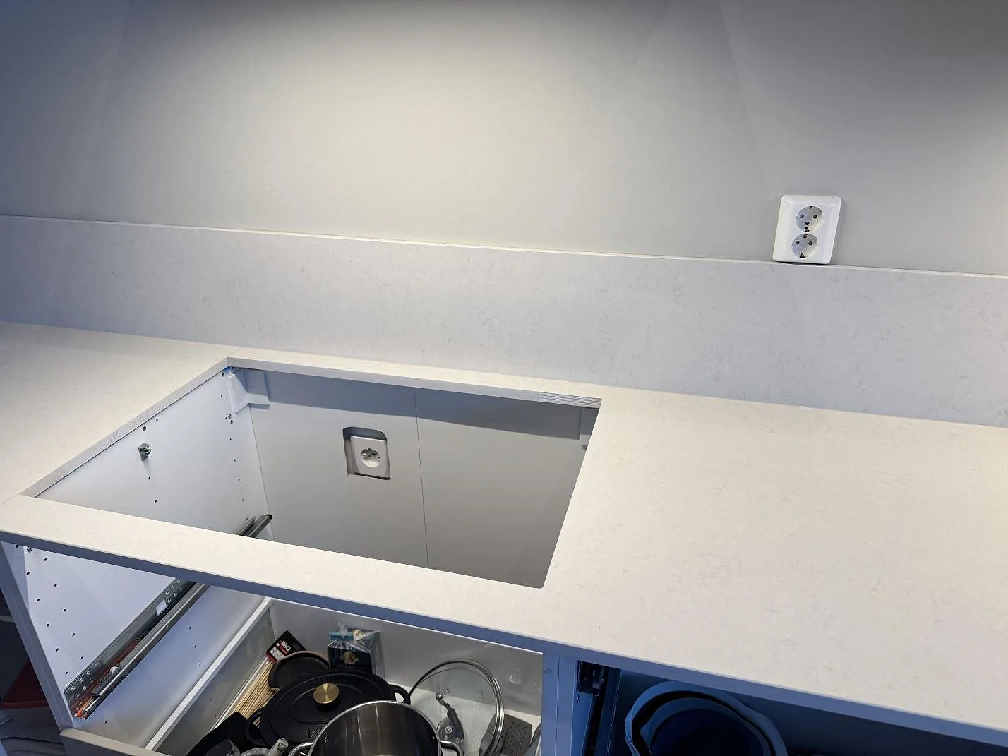 Ovanifrån av Silestone Linen Cream köksbänkskiva med urtag för häll över öppen stomme i ett kök i Växjö.